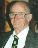 A smiling man in glasses with grey hair and wearing a suit