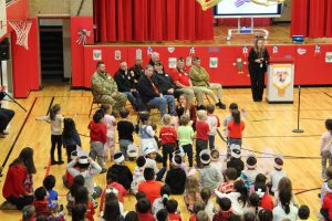 Students stand and sing for veterans