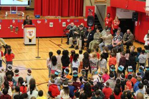 Students stand and sing for veterans