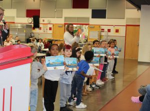 Students hold award certificates.