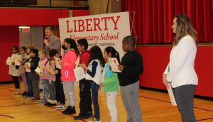 Students standing in a line hold certificates 