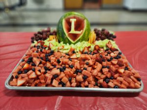 A fruit tray with the Liberty L carved into a watermelon