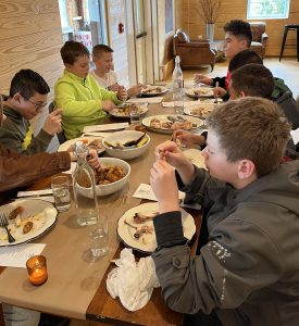 Students eat a meal at a long table