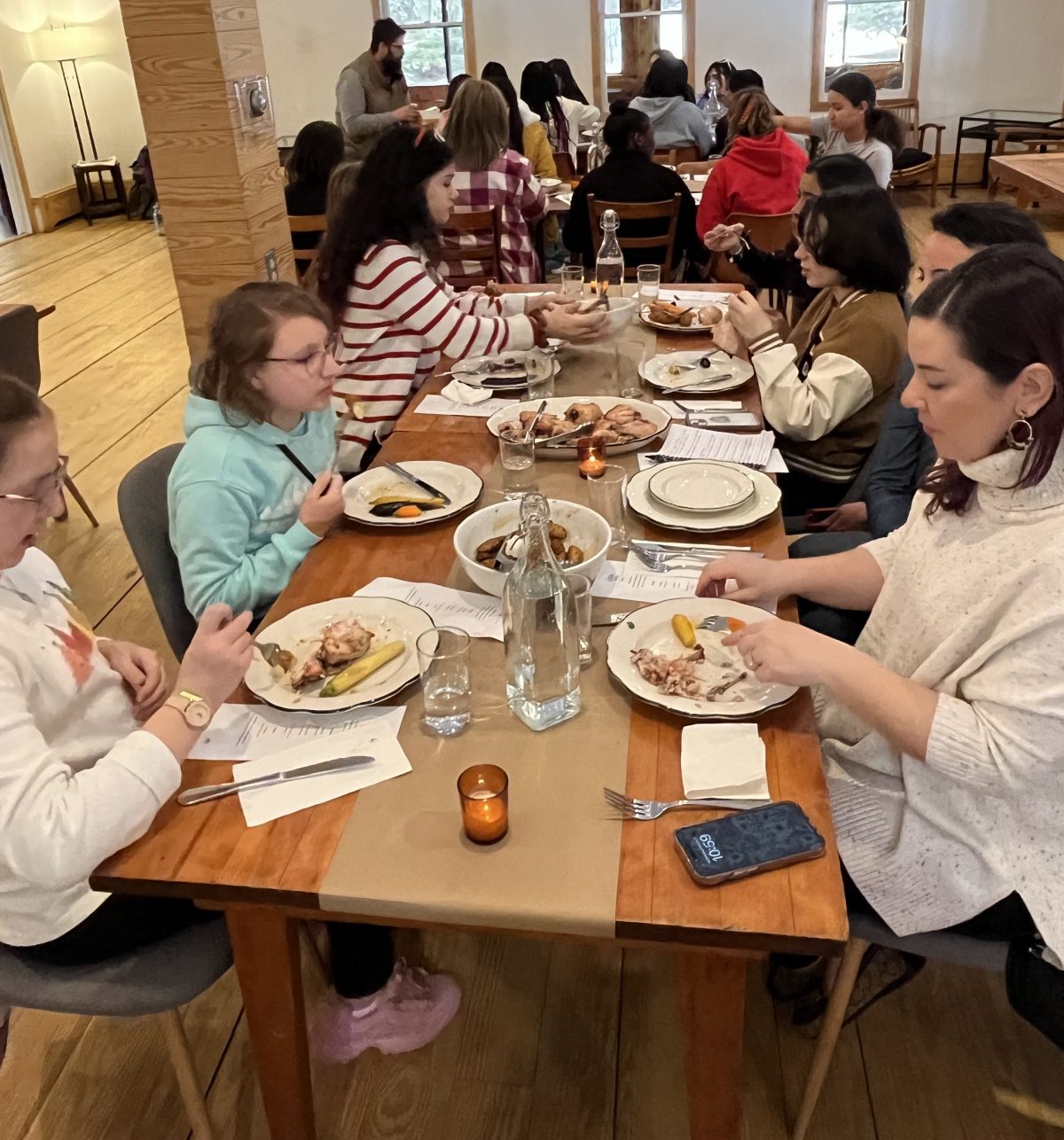 Students eat a meal at a long table