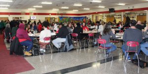 Adults eat breakfast in the cafeteria