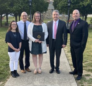 Five people stand in a line for a photo