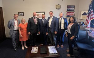 Seven people pose for a photo in an office