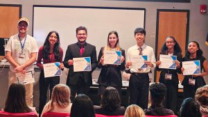 Seven people pose with certificates