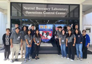 People pose in front of the Neutral Buoyancy Laboratory Operations Control Center