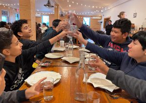 Students cheers with glasses at a table