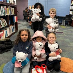 Five students hold stuffed polar bears