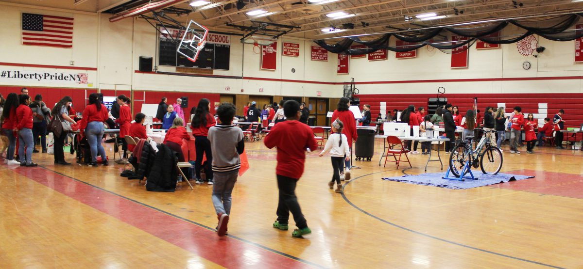The Liberty High School gym filled with people, tables and activities