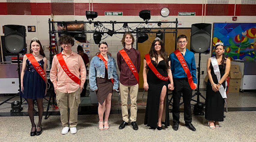 Students wearing sashes pose for a photo.