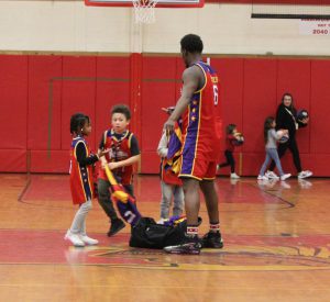 A Wizards player hands out jerseys to students