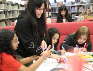 Students work on posters using markers