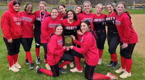 Liberty Redhawks softball players pose with a plaque