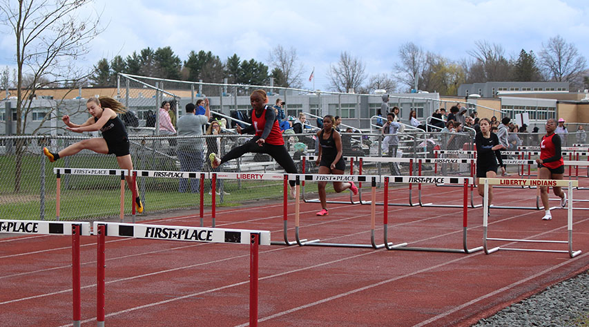 Athletes compete in hurdles