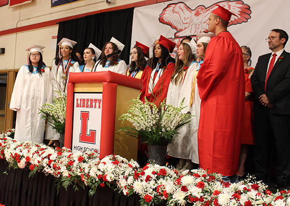 Students sing round a podium