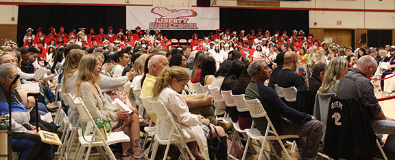 Graduates sit on stands as the audience watches