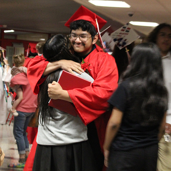 A graduate hugs and adult