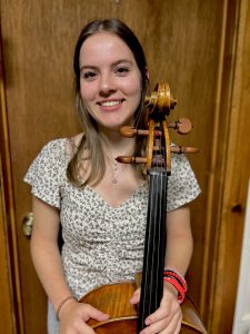 A student poses with a cello.