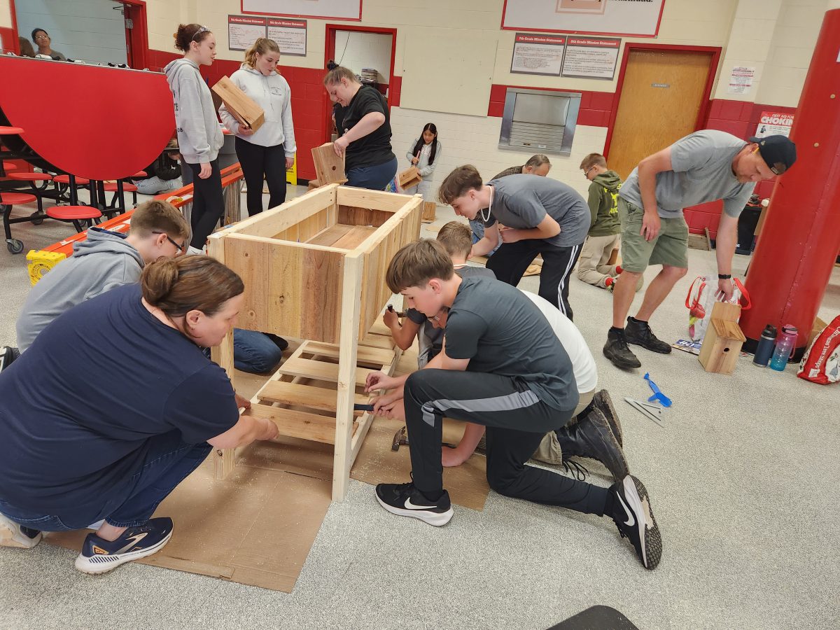Students work to build a raised garden bed.