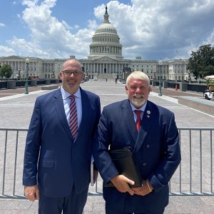 Two men pose outside the Capitol