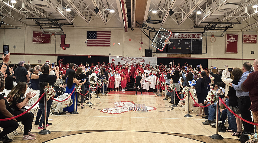 Graduates toss their caps.