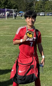 A soccer player holds a trophy.