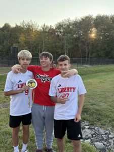 Three soccer players pose for a photo.