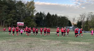 Members of the boys soccer team run across the field