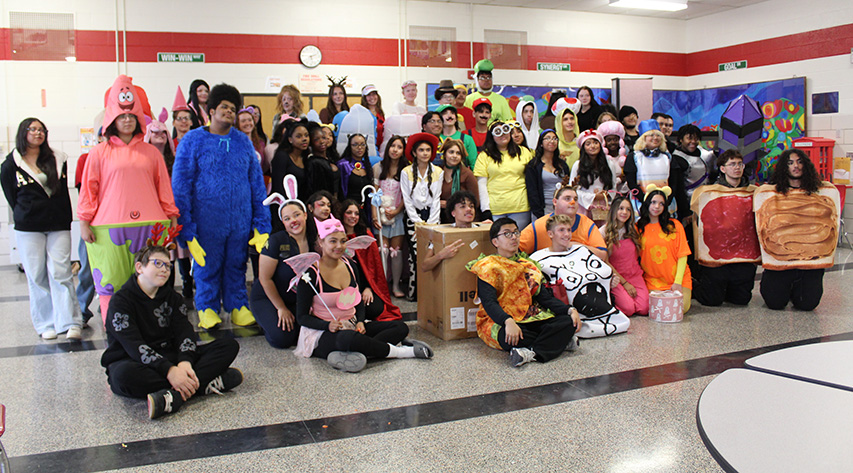 Students dressed in costumes for Halloween pose for a photo