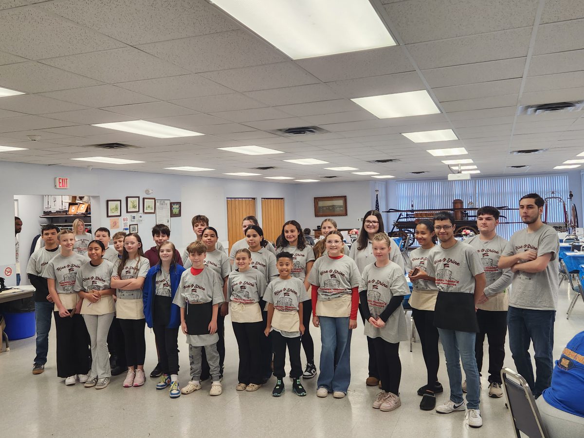 Students wearing "Rise and Shine" T-Shirts pose for a photo