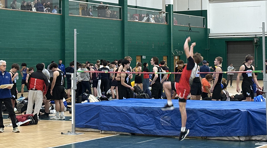 An athlete begins a leap over the bar in the high jump