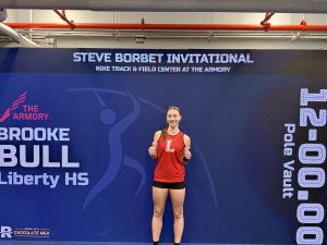 A girl give a thumbs up in front of a blue screen that reads Steve Borbet Invitational.
