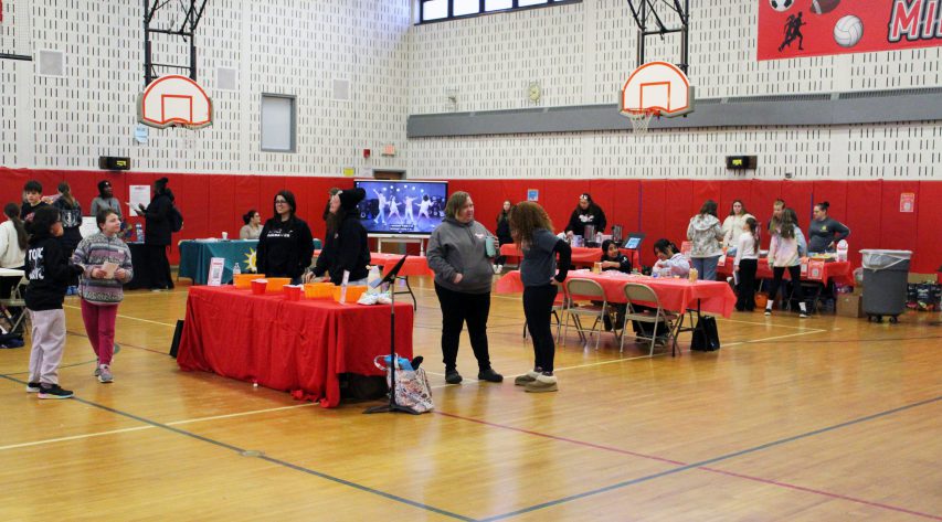 A gym is filled with tables and people
