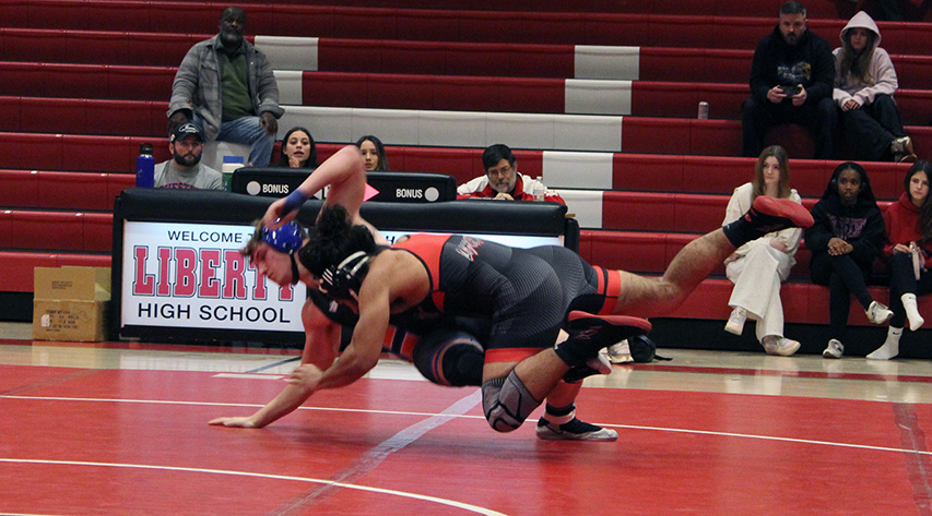 A wrestler throws a competitor to the mat