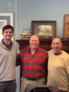 Three men pose for a photo