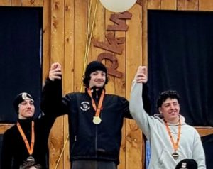 Three people stand on a podium