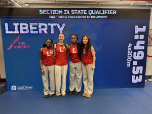 Four Liberty students pose in front of a blue screen with Section IX State Qualifiers. and Liberty on it.