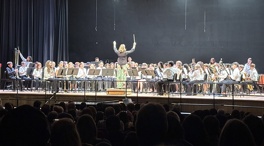 A director leads a band on a stage