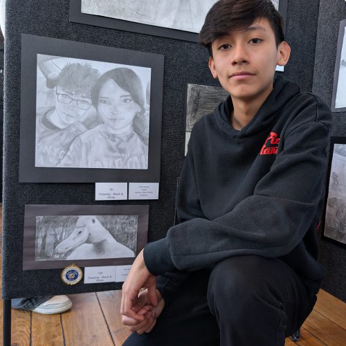 Alex A student poses next to a black and white drawing