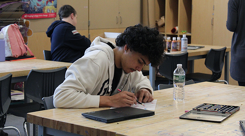 A student works intently on a drawing