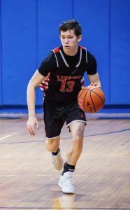 A student dribbles down the court.