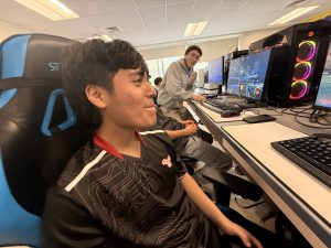 A student smiles as he competes in an esports competition.