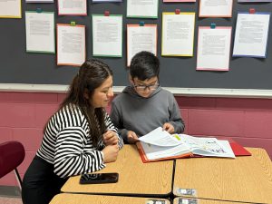 A student shows work to an adult