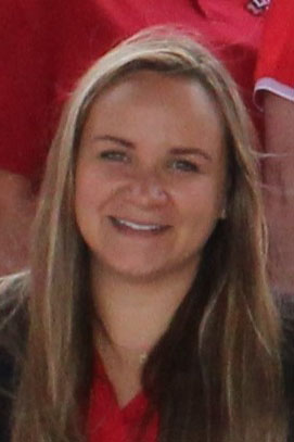 Headshot of brittany cunningham, a smiling woman with long brown hair wearing a red shirt.