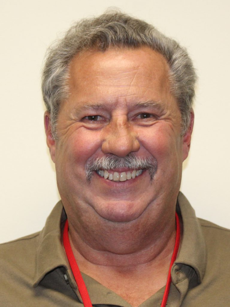 Headshot of randy kleingardner, a smiling man with short gray hair, a mustache, and a red lanyard.