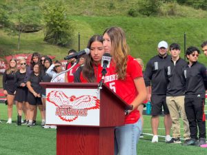 Two students speaking into mic on a podium