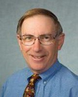 dr austin cantor, alumni of liberty and honoree of wall of fame, headshot, wearing a tie, blue shit, and glasses, smiling, facing camera